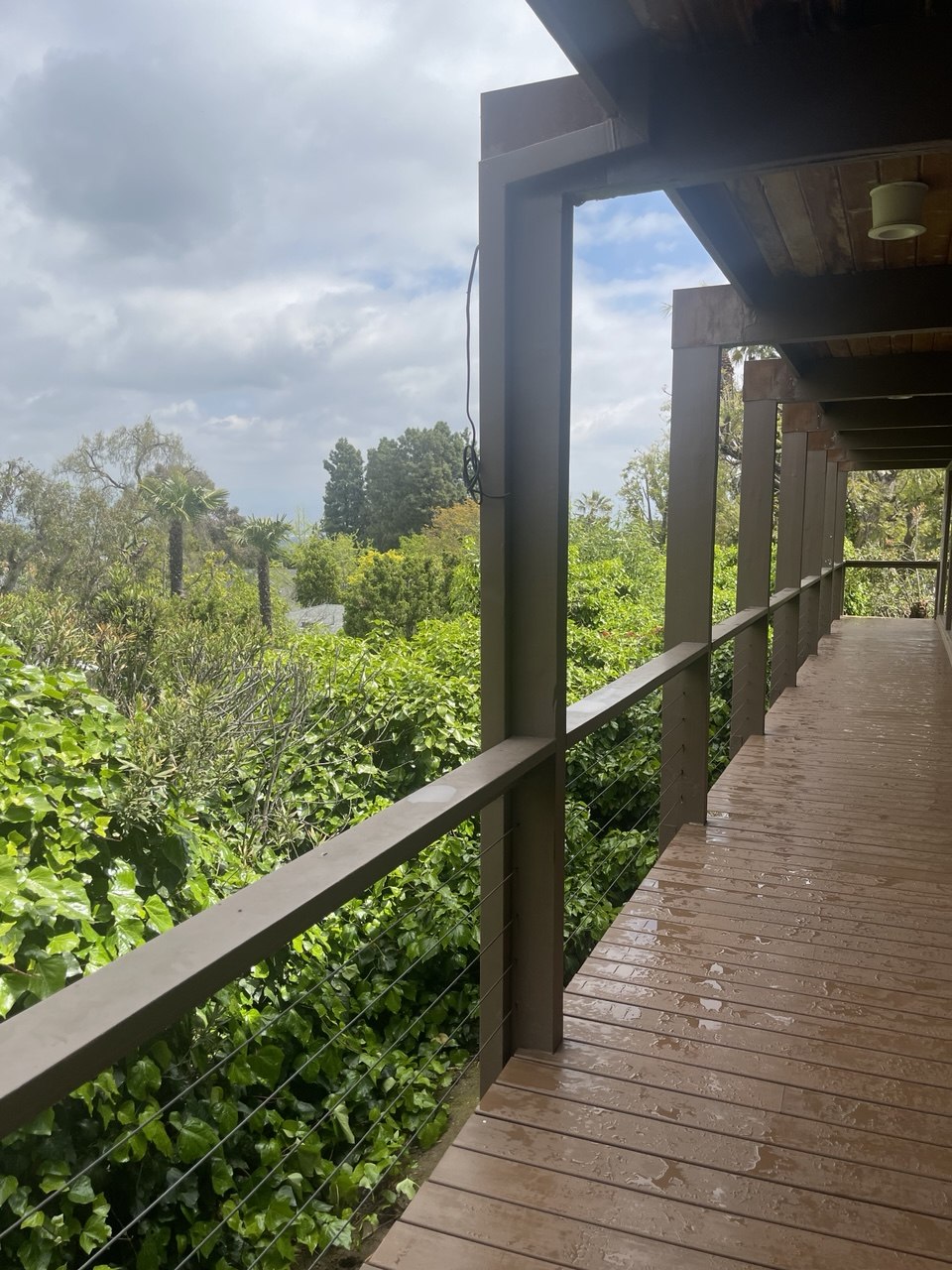 Covered wooden walkway with cable railing