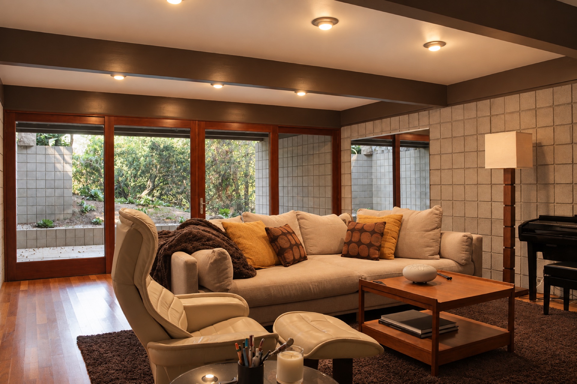Bright living room with grand piano and wood beam ceilings at The Gift House