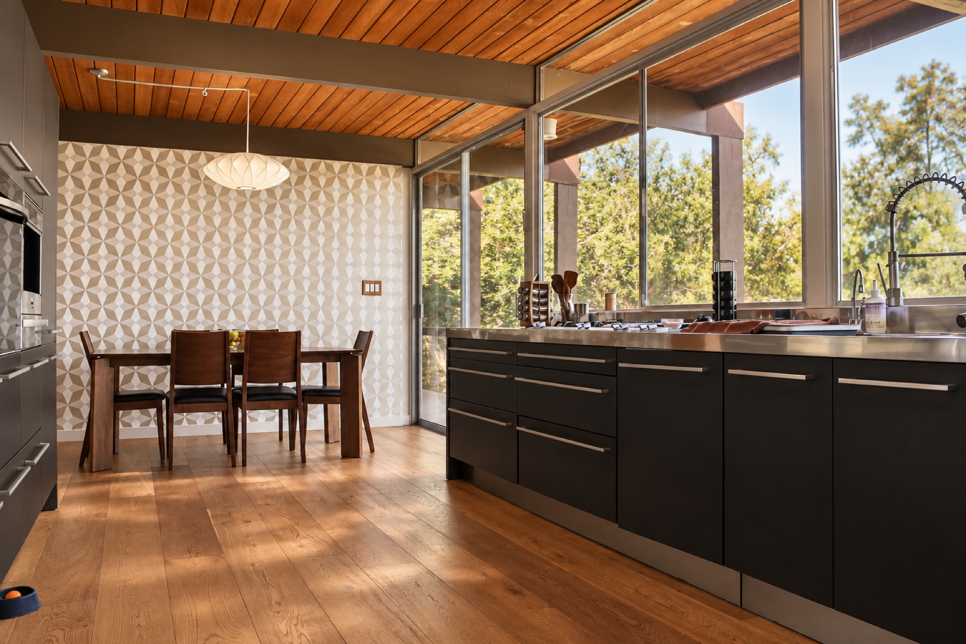 Open-concept kitchen and dining area with warm wood ceilings in a 1962 mid-century modern home